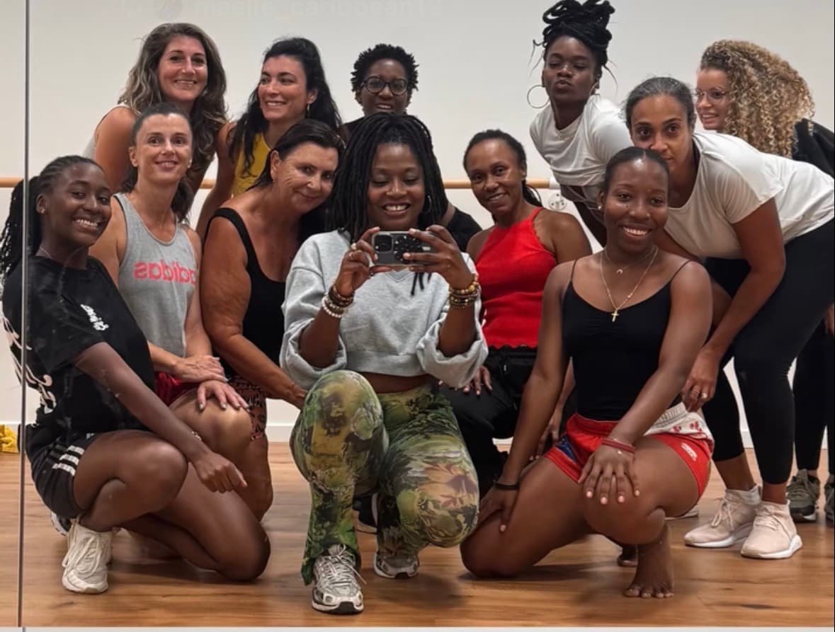 Groupe diversifié de femmes souriantes prenant un selfie miroir dans un studio de danse.